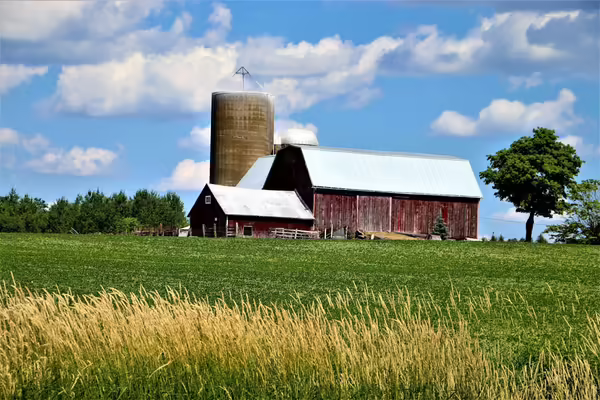red barn with white roof and silo