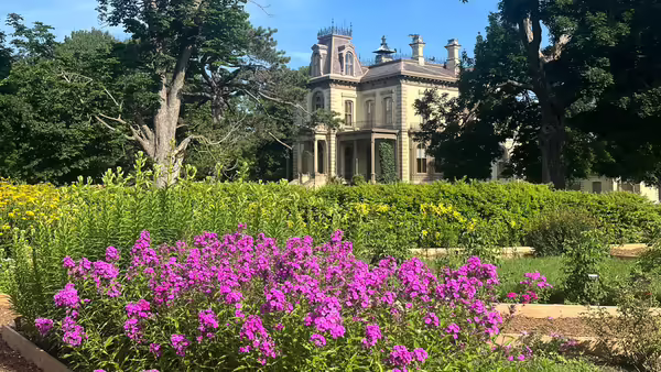 The historic David Davis Mansion in Bloomington, IL sits behind a bed of flowers from Sarah's Garden.
