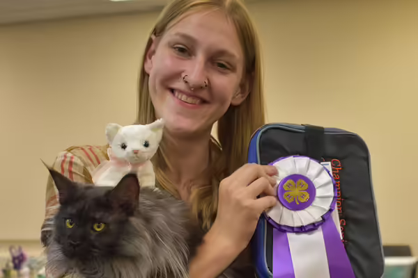 Youth holding ribbons and a cat