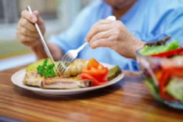 person eating a healthy meal of fish and salad 