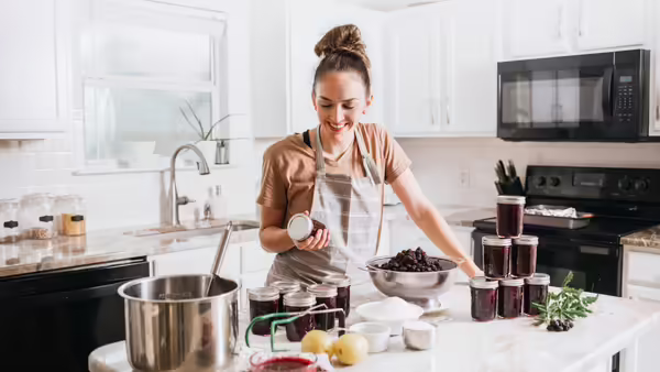 woman in kitchen canning fruit