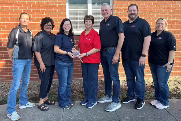 University of Illinois Extension staff member presenting the 2025 Community Partner Award to Borgic Farms.