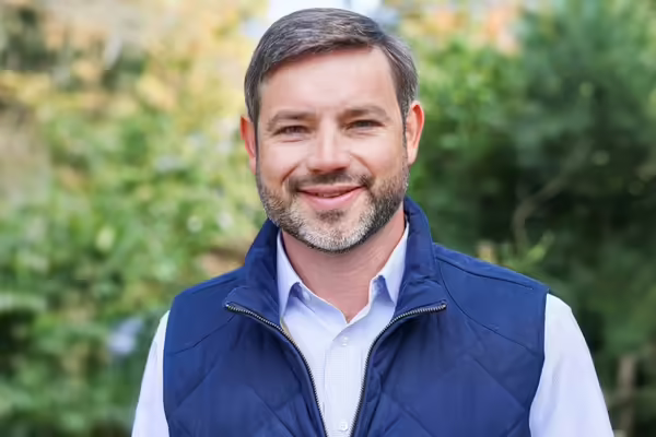Matthew Vann, Illinois Extension Associate Dean and Director, wears a blue vest over a light blue button -up shirt
