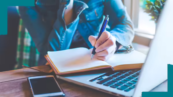 close up of person writing on notebook