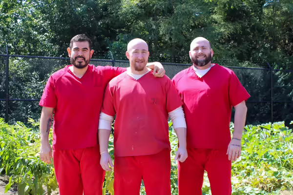 Jovanny Castaneda, Hallan Brady, and Derek Hornick pose in front of their garden