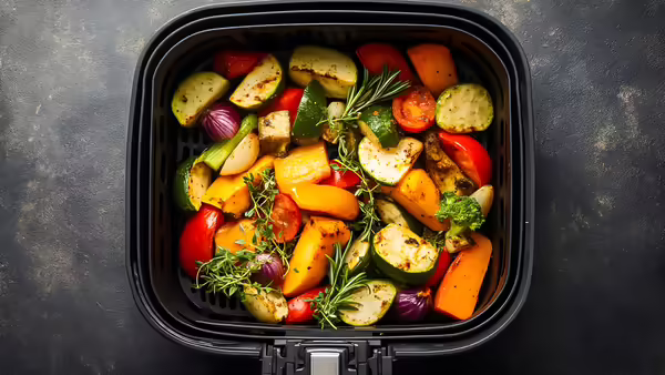 various vegetables in an air fryer tray