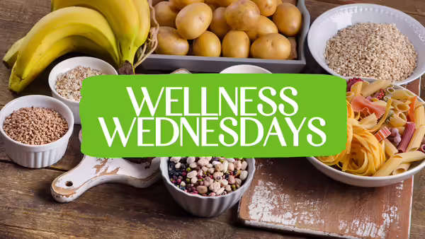 Wellness Wednesdays text centered on a green banner over a background of fresh vegetables and healthy ingredients.