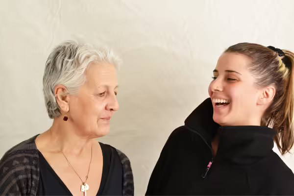 two women looking at each other, smiling