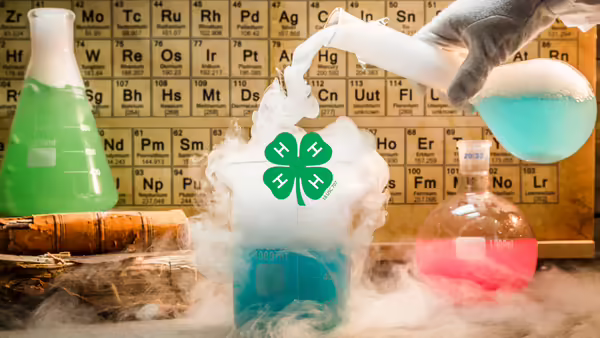 A science-themed graphic with a 4-H logo in a beaker that is smoking. The background shows beakers of colored liquid and a periodic table.