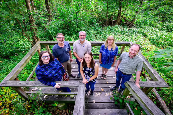 a group of people stand in a wetland