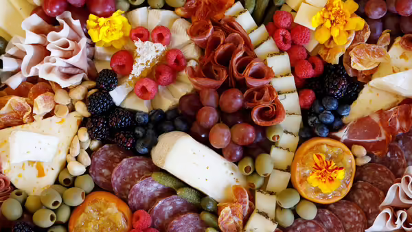 charcuterie board filled with meats, cheeses, fruits, and more