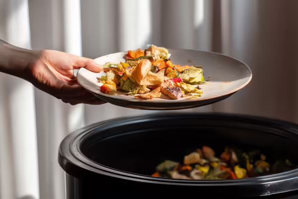 plate of uneaten food being thrown out
