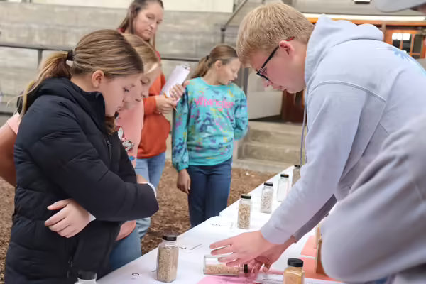 An ambassador shows younger members spices.