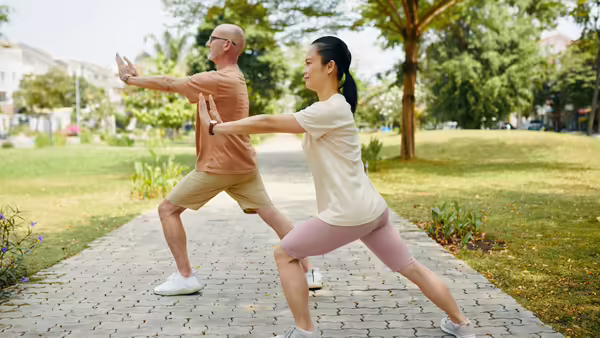 two people doing tai chi in a park
