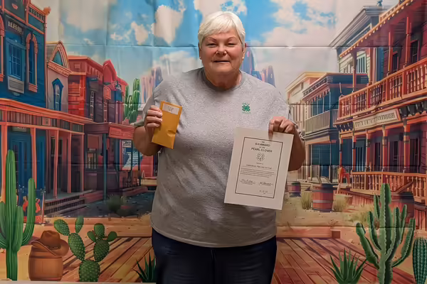 Woman with white hair standing holding certificate