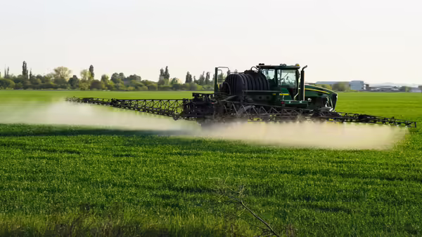 A sprayer spraying a field.