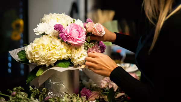 white and ivory flowers being arranged in a box