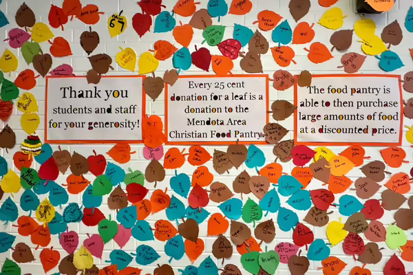 Colorful paper leaves and signage that explains the fundraiser displayed at Northbrook Middle School