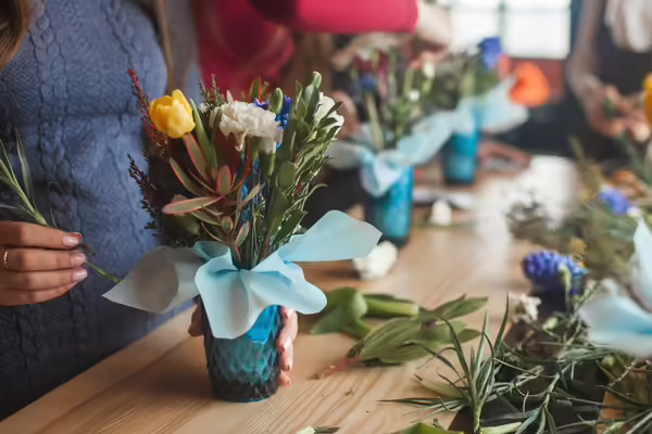 flower design class, hands inserting flowers into a vase