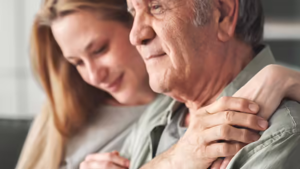 woman with arms around man's shoulder