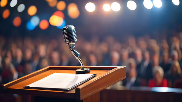 podium with microphone in front of audience