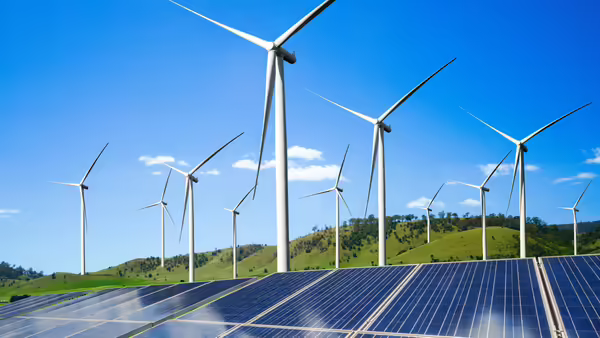 Solar panels and wind turbines in a field.
