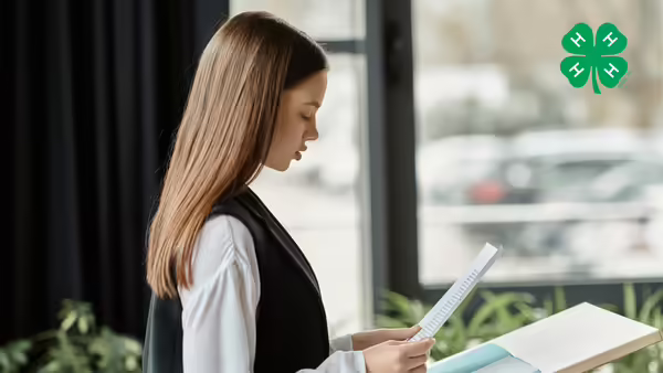 Girl with paper speaking and a clover