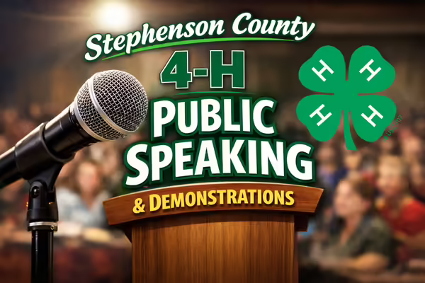 blurred background of people in an audience with a microphone near the front left side of the image.