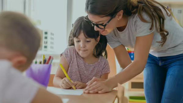 A teen girl tutoring a young girl