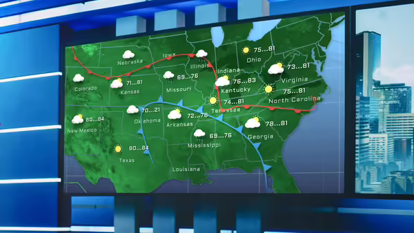 a screen in a television studio with a map showing weather across the united states