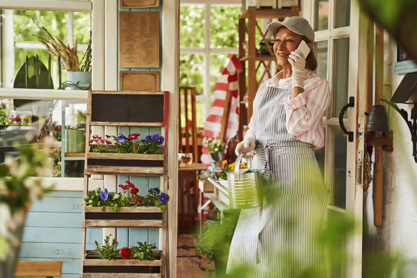 woman in greenhouse porch making a phone call