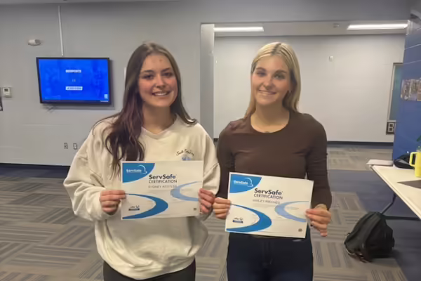 Two youth pose with their certifications.