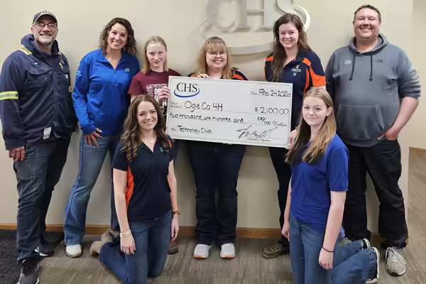 group of adults standing with big check