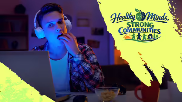 Person snacking at their desk with the words "Healthy Minds, Strong Communities"