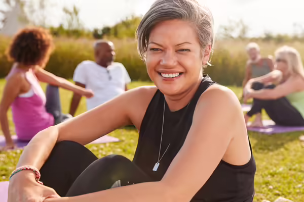 A woman smiling and exercising outdoors