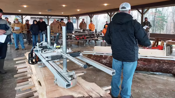 A person standing in front of a sawmill