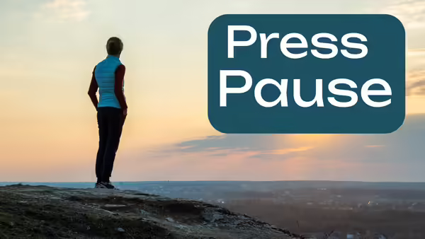 Person standing looking out over land in a sunset