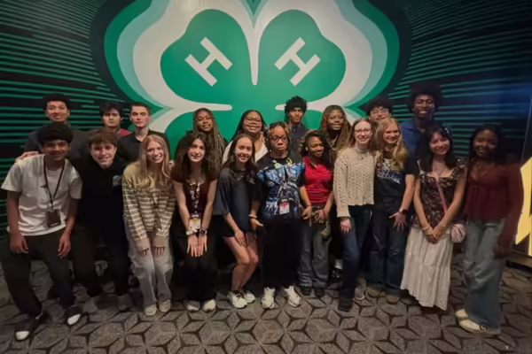 Ignite delegates pose by giant clover.