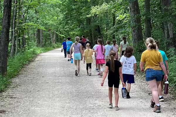 Youth walking on road in woods