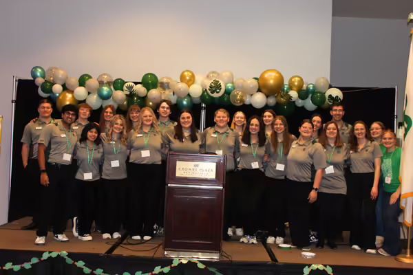 Youth Leadership Team members pose in front of leaf balloons. 