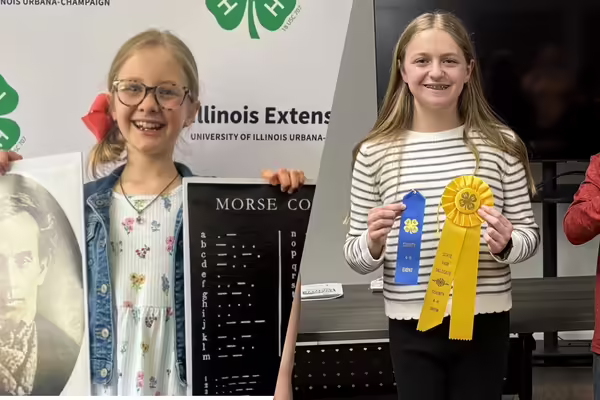 Two youth hold up ribbons