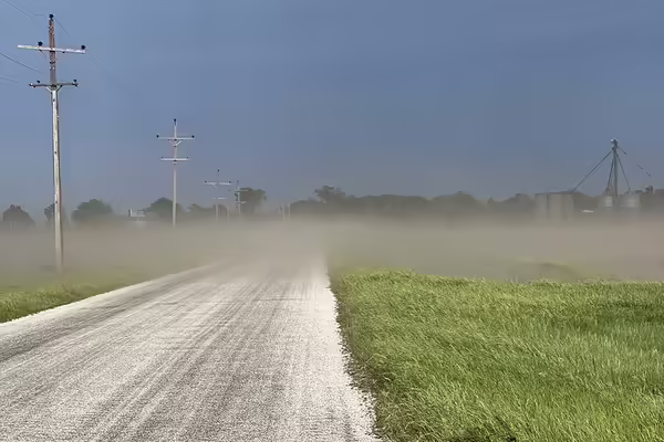 dust blowing across a rural road