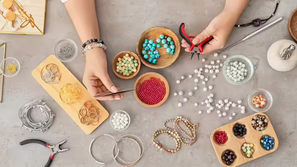 A person using metal tools to create bracelets. 
