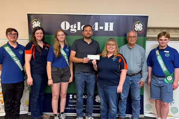 Group of youth and adults standing with check.