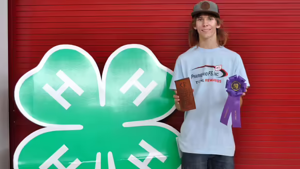 4-H member in front of 4-H Clover