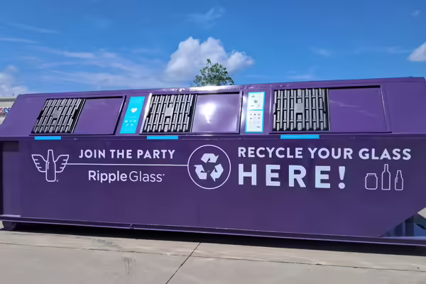 A purple glass recycling dumpster.