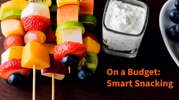 Different kinds of fruit on a skewer with cup of yogurt