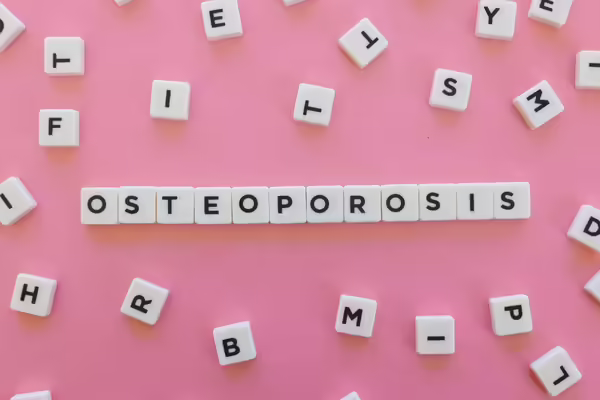 Osteoporosis spelled out in beads on a pink background