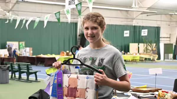 a girl showing her 4-H quilt project