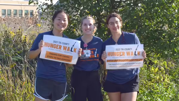 three girls holding Hunger Walk signs